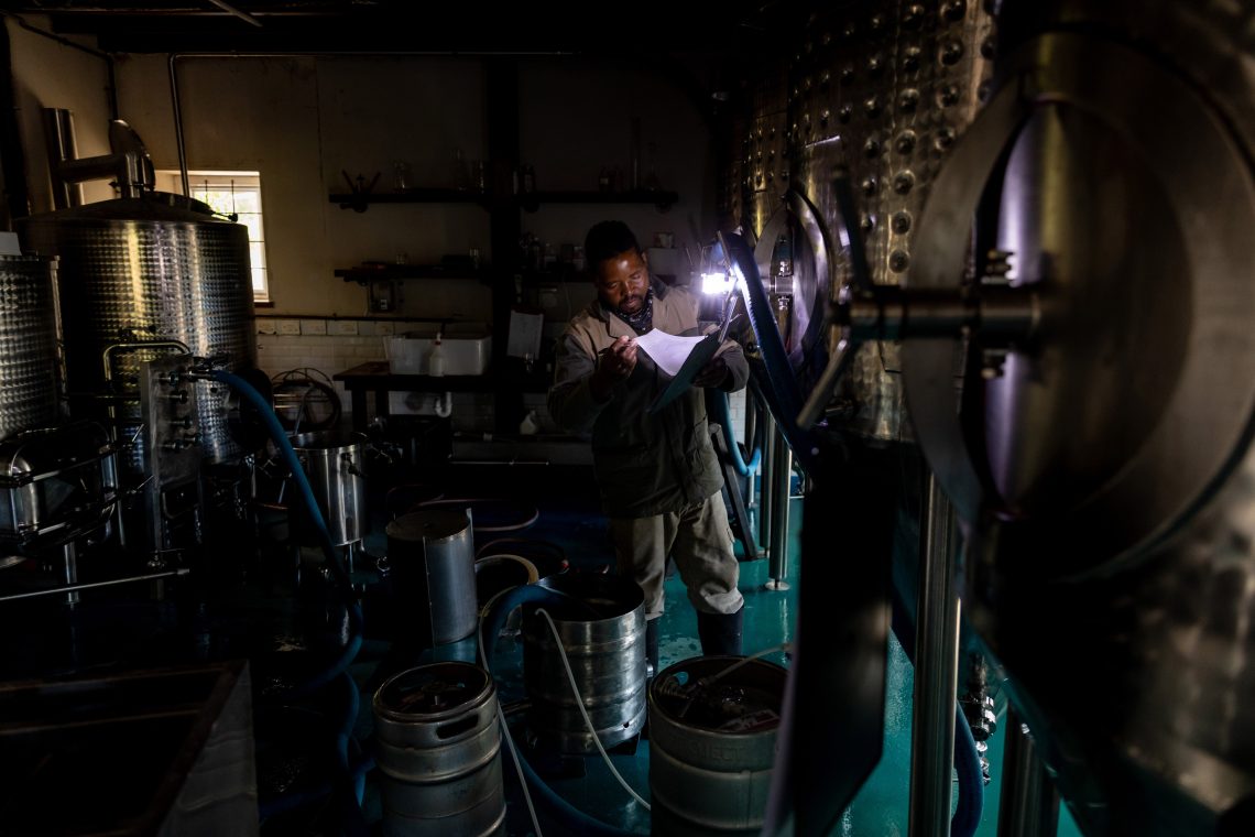 Working by flashlight at a South African brewery during a blackout