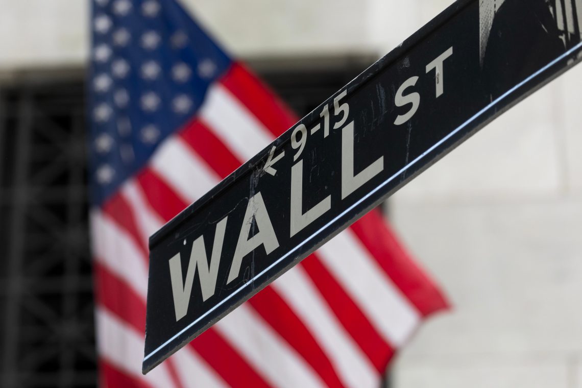 A Wall Street street sign in front of the New York Stock Exchange (NYSE)